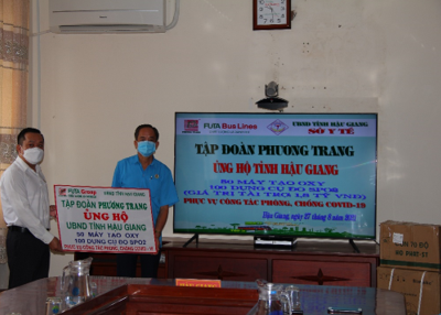 Ông Hà Duy Tuấn (bìa trái), Giám đốc Cụm 5, Tập đoàn Phương Trang, trao bảng tượng trưng ủng hộ thiết bị cho BSCK2. Nguyễn Thanh Giang, Phó Giám đốc Sở Y tế tỉnh.