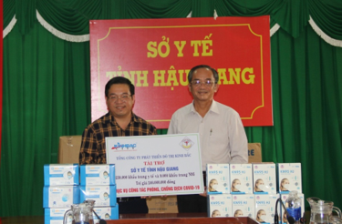 Ông Phan Minh Toàn Thư (trái), Giám đốc Tổng Công ty Phát triển đô thị Kinh Bắc, trao bảng tượng trưng tài trợ 239.000 khẩu trang y tế cho ông Nguyễn Thanh Giang, Phó Giám đốc Sở Y tế tỉnh.